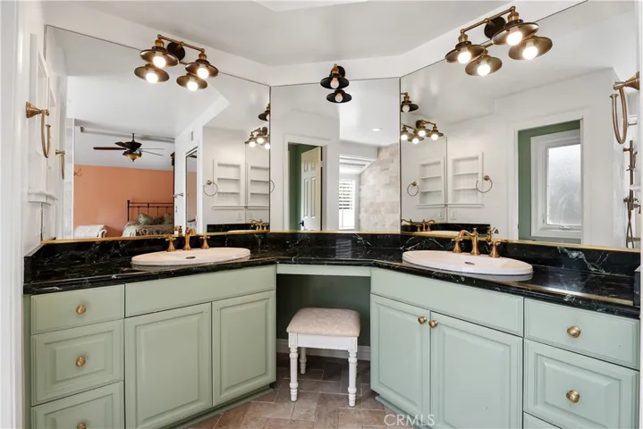 Primary suite bathroom. Vanity area, double sinks, and water closet.