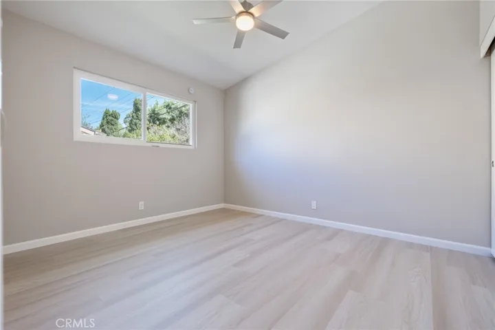 Second bedroom with ceiling fan, pitched ceilings and extra closet space.