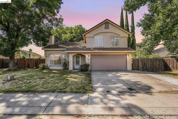 Traditional-style home with a garage, stucco siding, concrete driveway, and a chimney