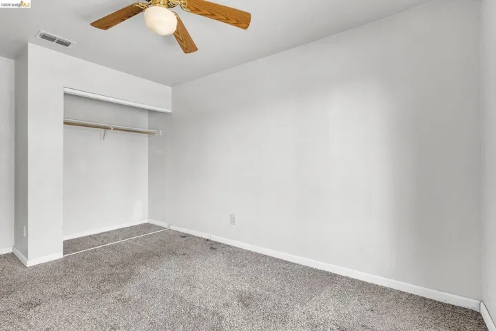 Unfurnished bedroom featuring carpet flooring, a closet, and ceiling fan