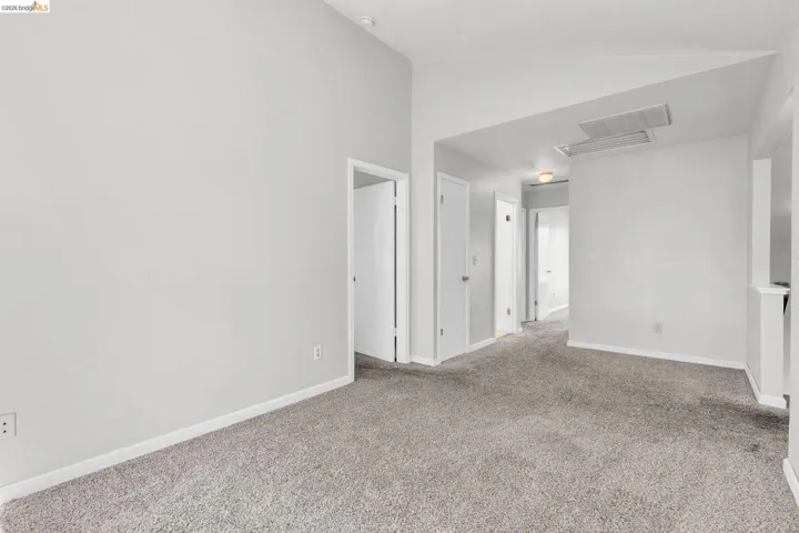 Unfurnished room with vaulted ceiling and carpet flooring