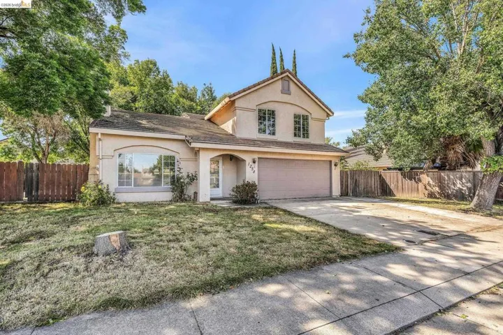 Traditional-style home featuring stucco siding, concrete driveway, an attached garage, and a tiled roof