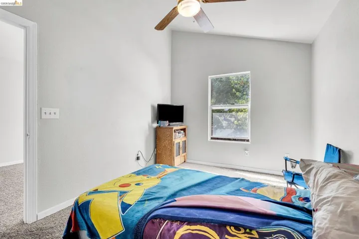 Bedroom with light carpet and a ceiling fan