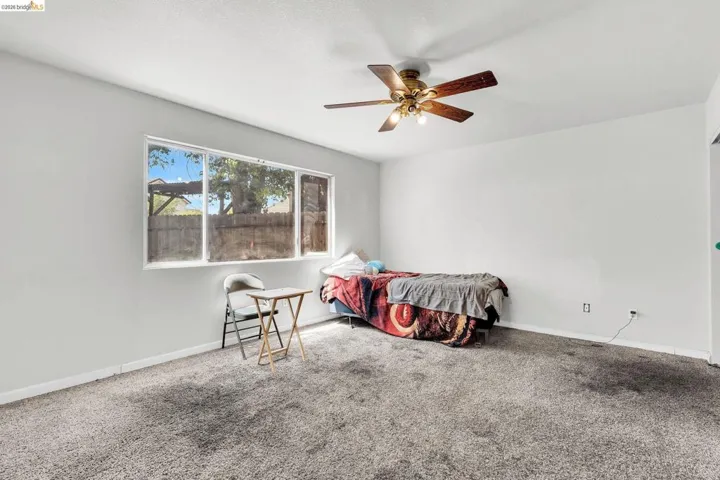 Carpeted bedroom featuring baseboards and ceiling fan