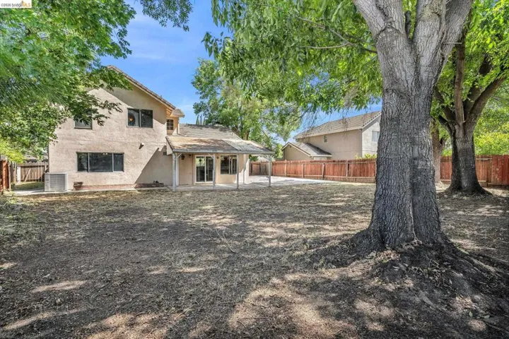 Rear view of property featuring a patio, stucco siding, and a fenced backyard