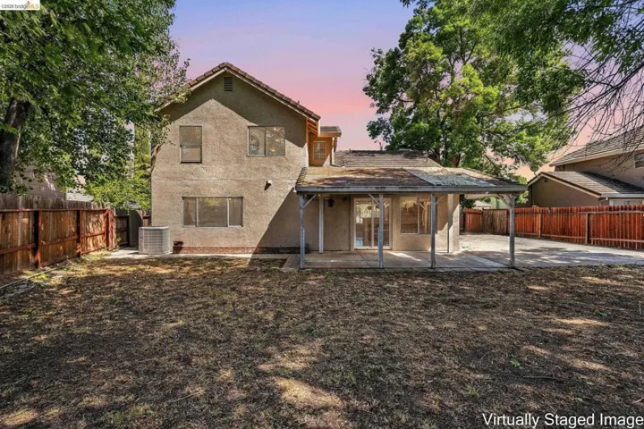 Back of property at dusk with a patio, stucco siding, and a fenced backyard