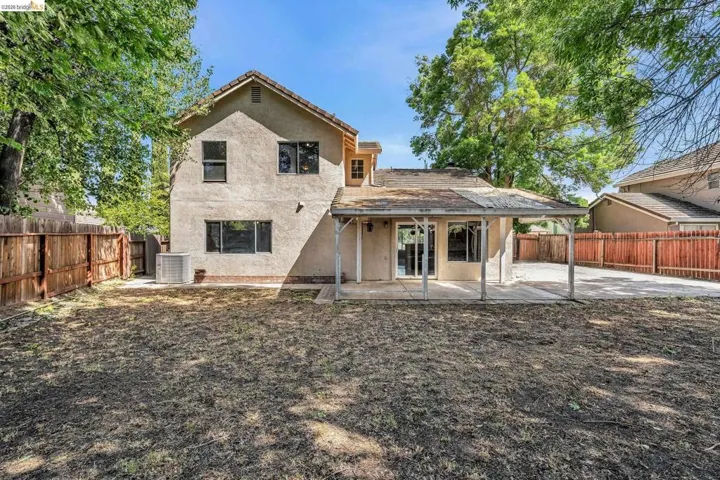 Rear view of property featuring a patio, stucco siding, and a fenced backyard
