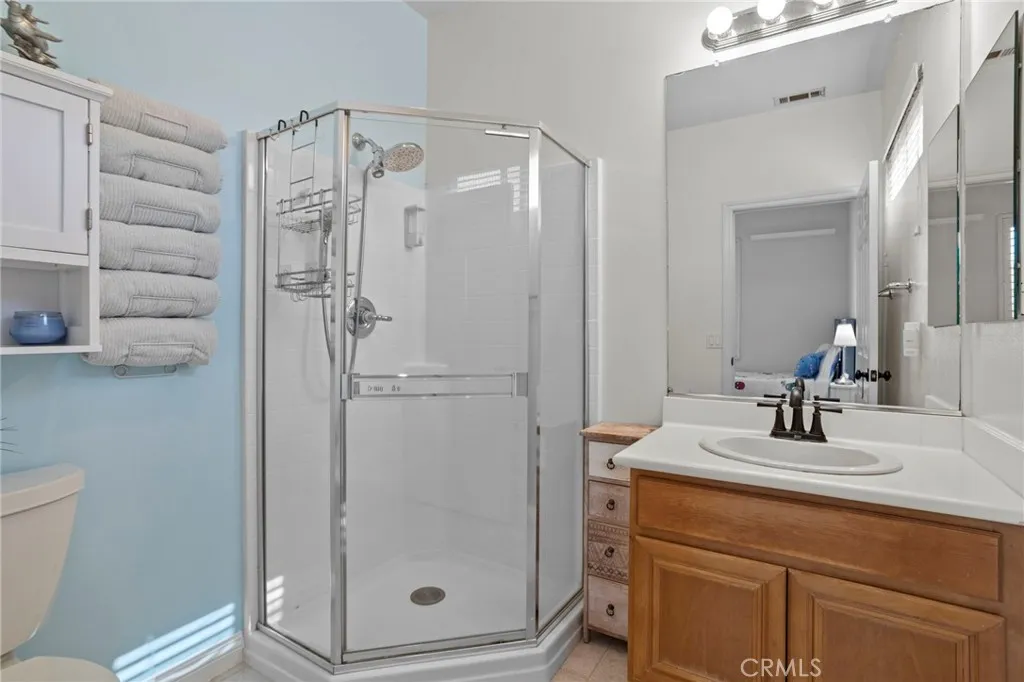 Bathroom with a single-sink vanity and glass-enclosed shower