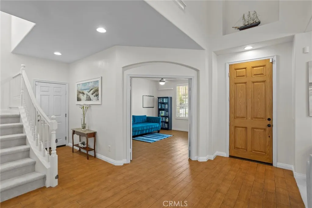 Bright entry with soaring ceilings, wood flooring, and an open layout