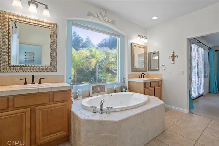 Spacious primary bathroom with dual vanities and a soaking tub