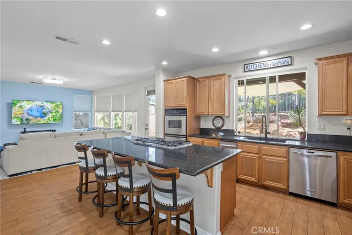 Kitchen with island cooktop, bar seating, and seamless flow to the family room