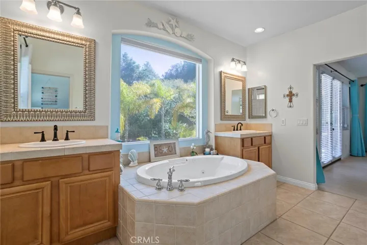 Spacious primary bathroom with dual vanities and a soaking tub