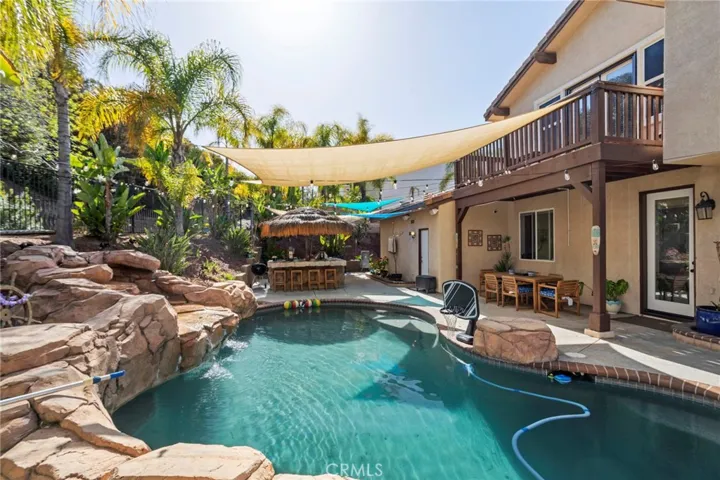Backyard with a resort-style pool and shaded outdoor entertaining area