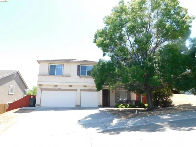 View of front of home with a garage, concrete driveway, and stucco siding