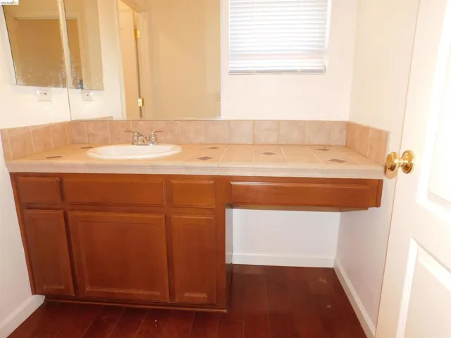 Bathroom featuring vanity and dark wood-style flooring