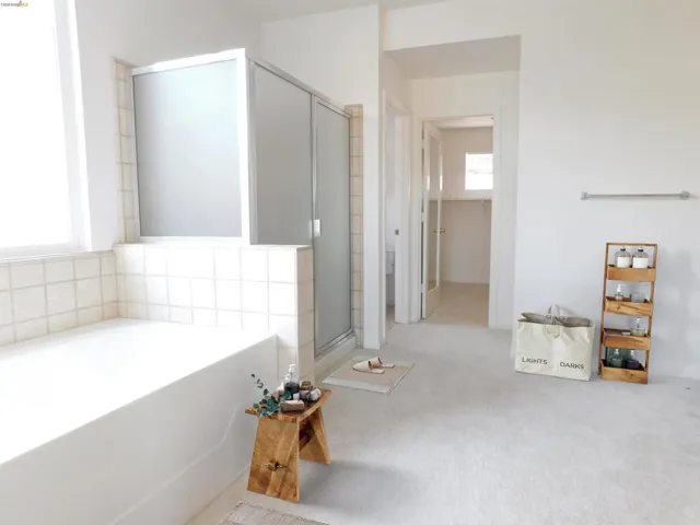 Full bath featuring a garden tub, a stall shower, and light colored carpet