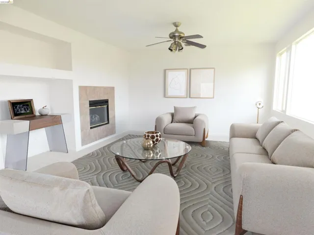 Living room with a tile fireplace and ceiling fan