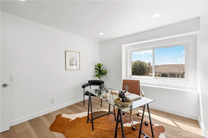 Bright workspace with large window, offering natural light and neighborhood views.