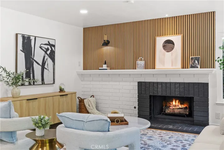 Cozy living area featuring a fireplace, accent wall, and stylish finishes.