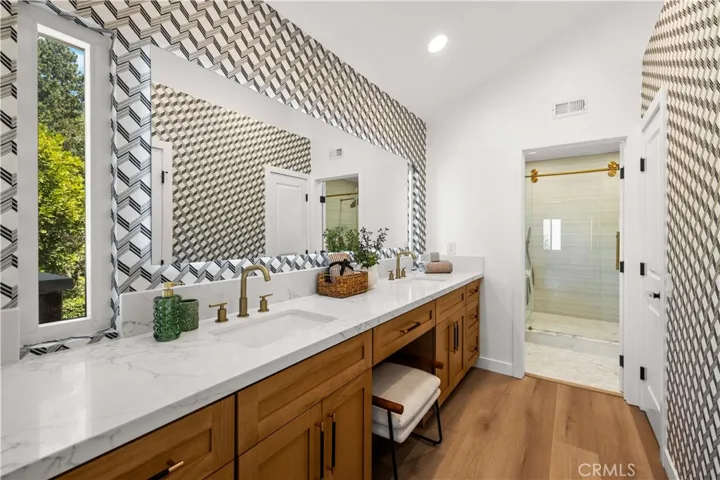 Modern primary bathroom featuring dual vanities, large mirror, and a clean, updated design.
