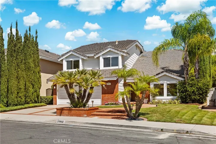 The front view showcases the well-maintained exterior and landscaping, with a clear view of the driveway and inviting front entry, adding to the curb appeal of the home.