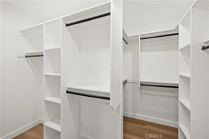 Walk-in closet with built-in shelving and ample hanging space for organized storage.