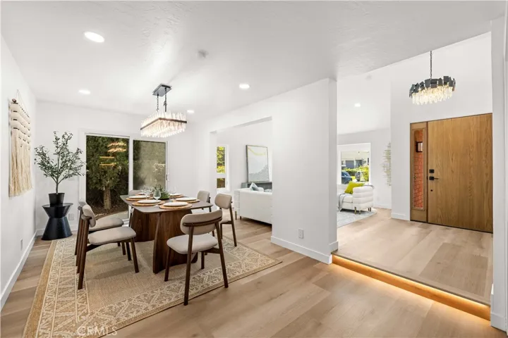 Dining area with modern lighting, offering a clean layout and view toward the entry and living spaces.