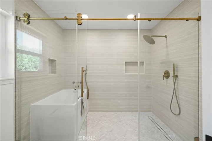 Elegant bathroom featuring a glass-enclosed shower, separate tub, and sleek, updated finishes.