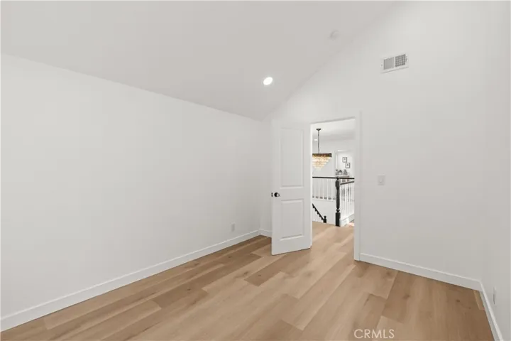 Spacious third bedroom featuring high ceilings, bright window views, and a simple, open design.