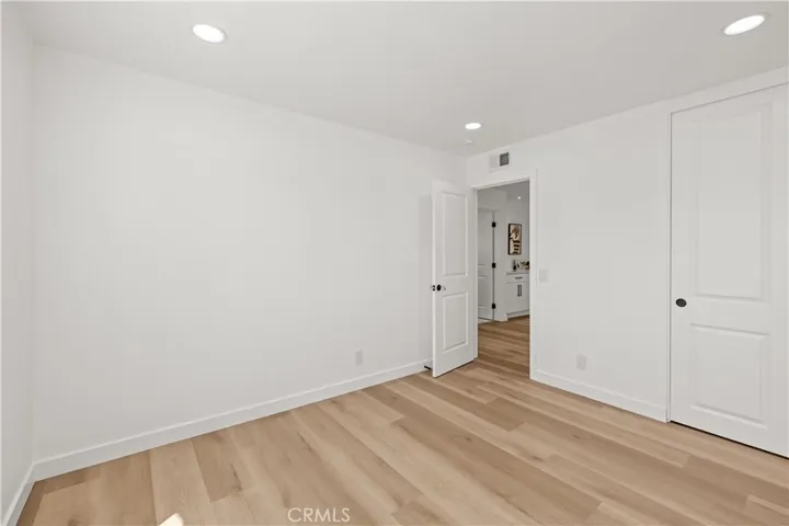 Spacious second bedroom with high ceilings, large window, and a bright, airy feel.