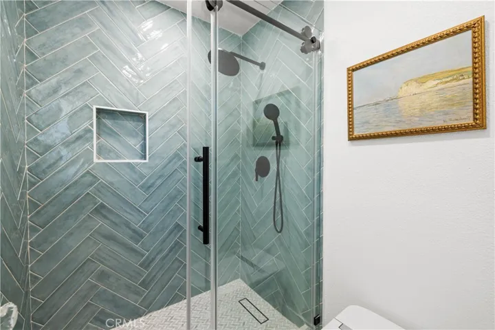 Shower area with glass enclosure and stylish tile design, offering a clean and modern look.