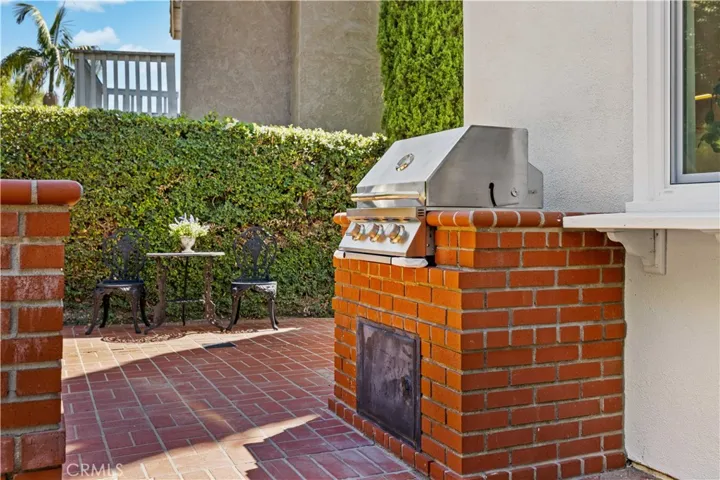 Outdoor BBQ area with built-in grill and brick accents, perfect for entertaining.