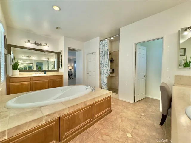 Grand Primary Bedroom Suite Bathroom with large soaking tub, separate vanities, water closet, and large walk-in closet and shower.