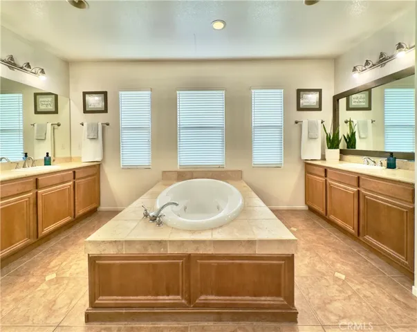Grand Primary Bedroom Suite Bathroom with large soaking tub, separate vanities, water closet, and large walk-in closet and shower.