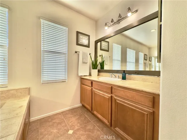Grand Primary Bedroom Suite Bathroom with large soaking tub, separate vanities, water closet, and large walk-in closet and shower.