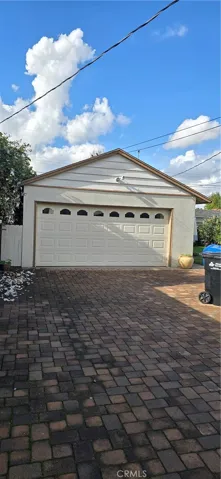 GARAGE W/ AUTO ROLL UP DOOR AND DRIVEWAY VIEW.