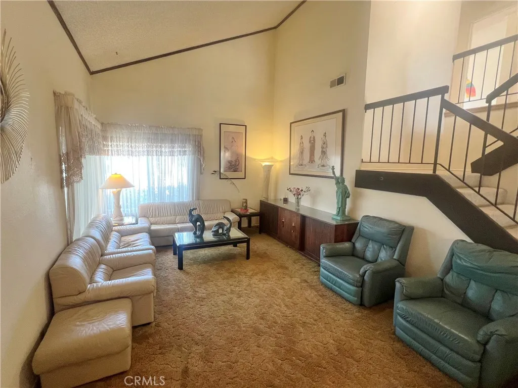 View of the Living Room from a distance showing a very high ceiling that helps maintain a comfortable climate inside the home as heat rises to the top.