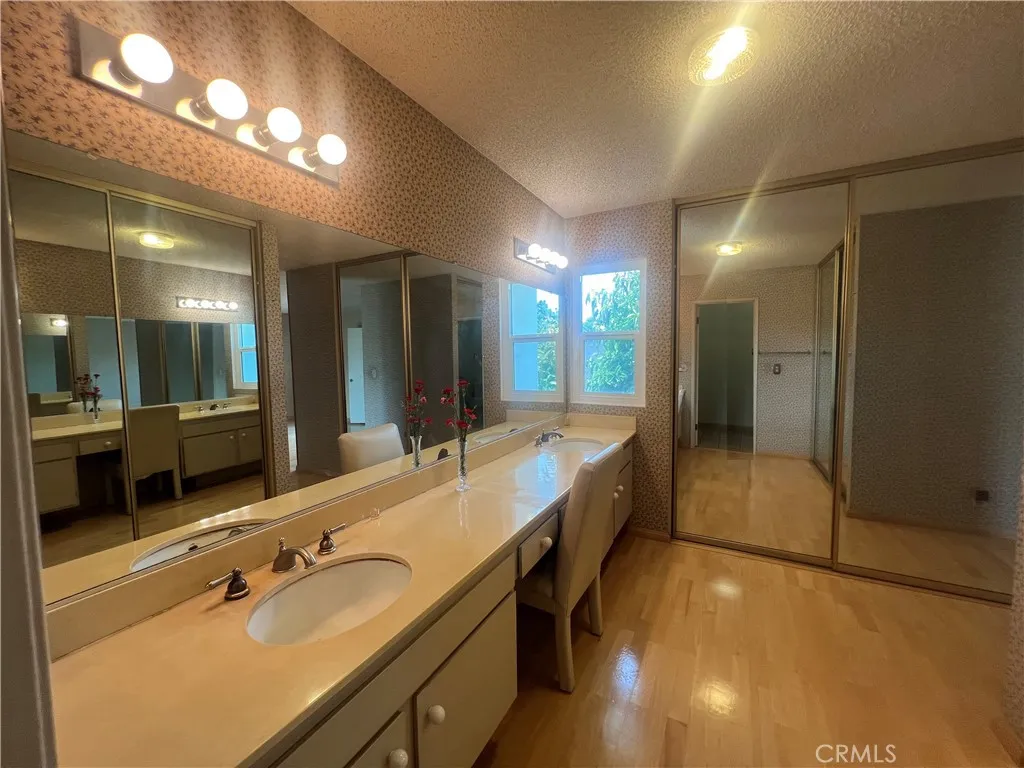 Primary Bathroom View of His and Her Sink and Vanity Mirror and Closets