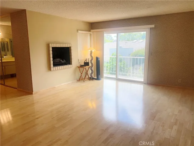 View of the Primary Suite's Fireplace Next to the Sliding Glass Door to the Balcony