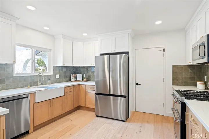 Large kitchen w/ new cabinetry, quartz counters, farmhouse sink, and designer touches!