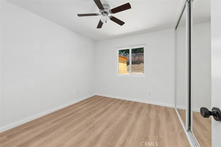 Bedroom with ceiling fan and updated flooring provides a calm, comfortable retreat. Its clean lines and neutral palette create an easy, relaxed atmosphere.