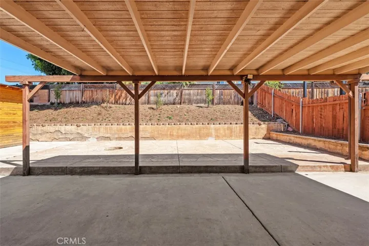 Covered patio creates a generous outdoor living space with plenty of room for dining, relaxing, or weekend gatherings. The overhead cover adds shade and year-round usability.