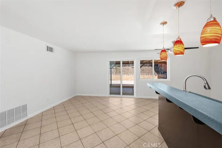 Dining space opens nicely toward the kitchen and rear yard, creating a natural gathering area for daily meals or casual entertaining. Sliding glass doors bring in light and add indoor-outdoor appeal.