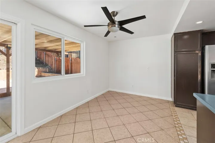 Dining area just off the kitchen feels bright and inviting, with a ceiling fan overhead for added comfort. It is an easy spot for morning coffee or weeknight dinners.