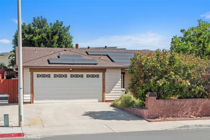 The front elevation highlights the attached two-car garage and low-maintenance yard, creating a practical and polished first impression. Mature greenery adds warmth and character to the exterior.