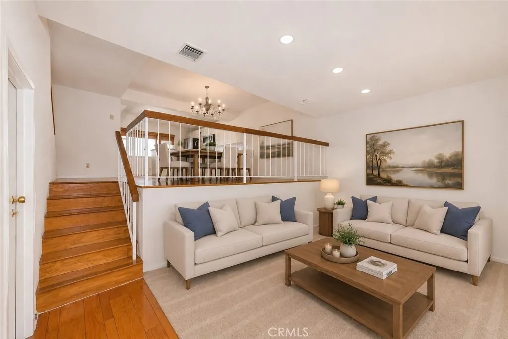 Virtually Staged Digitally altered photo of the living room with stairs to dining area
