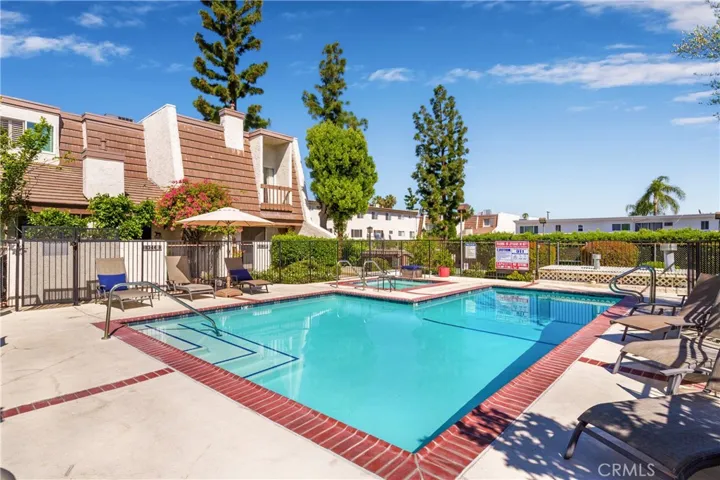 Pool area with view of subject property. Corner unit.