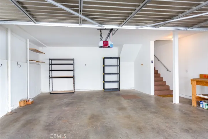 Interior of attached two car garage with stairs to living area