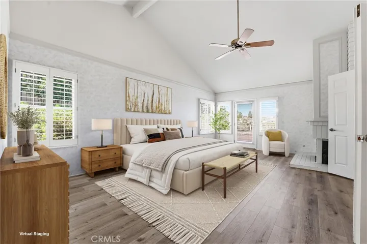 Spacious primary suite with with fireplace and access to the tranquil backyard views (virtually staged).