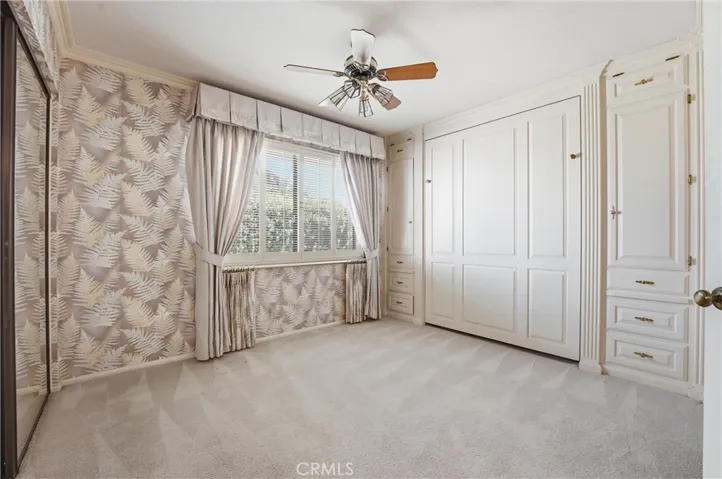 This spacious secondary bedroom has ample built-ins including a Murphy bed.